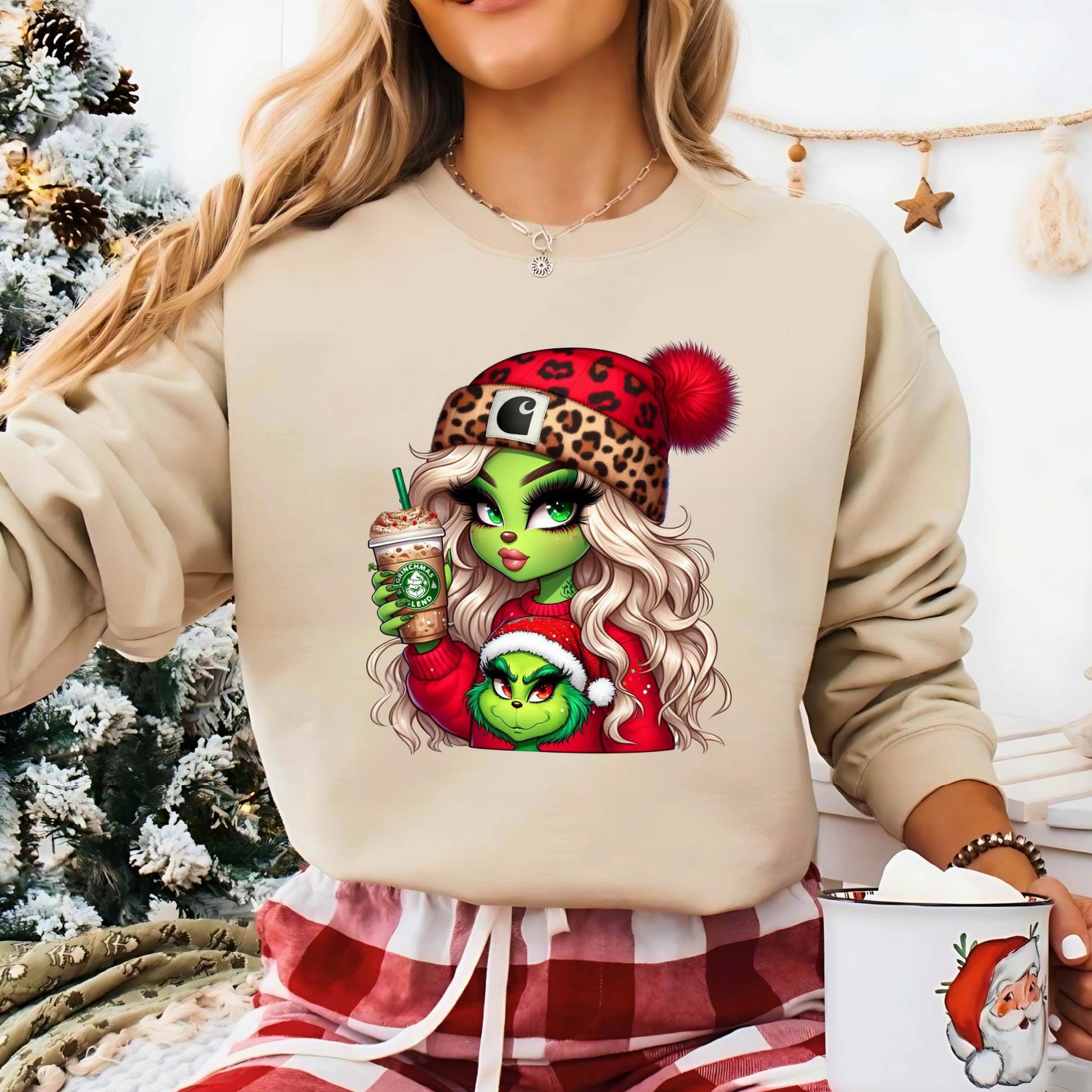 Festive cozy scene with a woman in a sand-colored sweatshirt featuring the Green Girl and holiday coffee art.