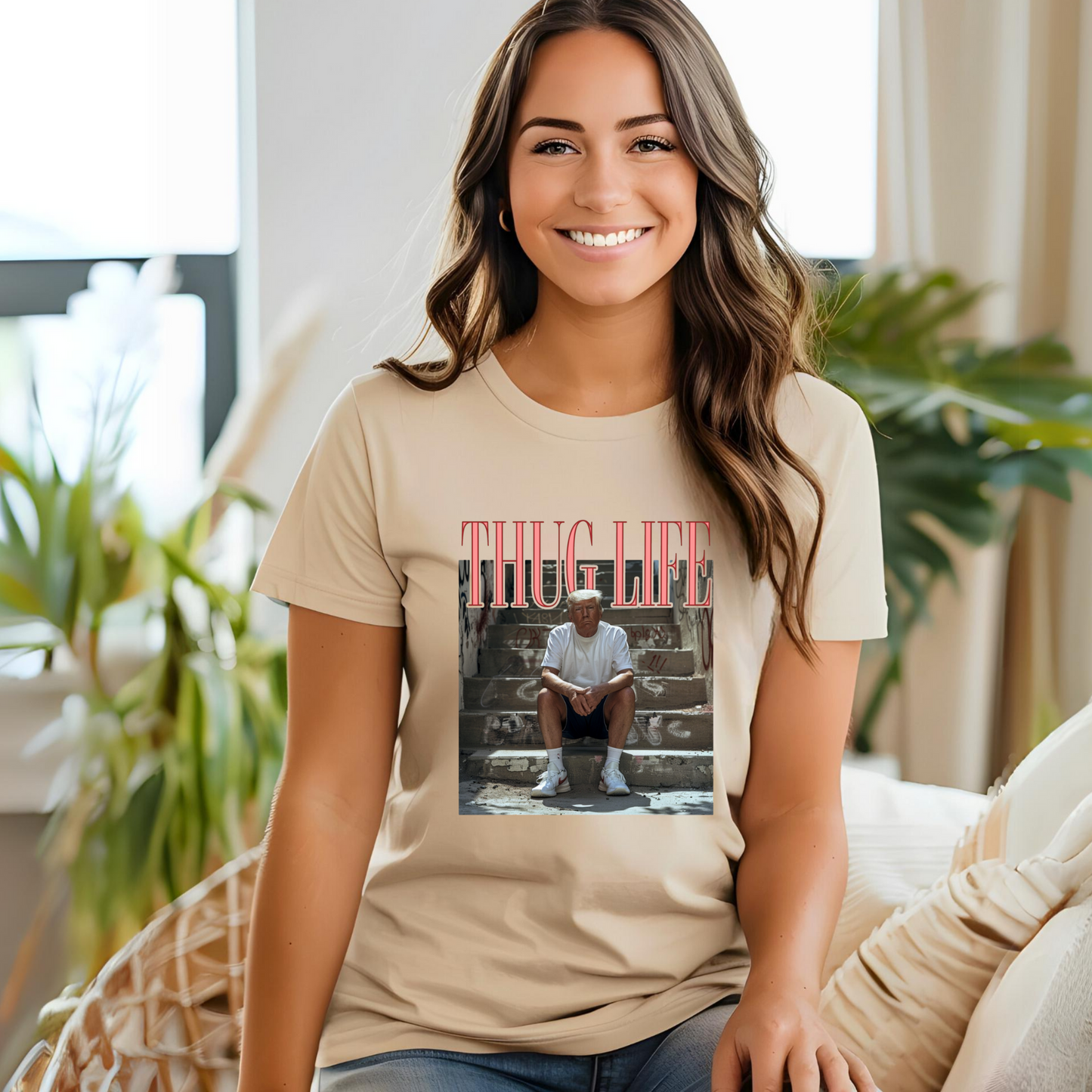 A person wearing a white crew neck t-shirt with a graphic print of a man sitting on steps and the text 'THUG LIFE' above the image.