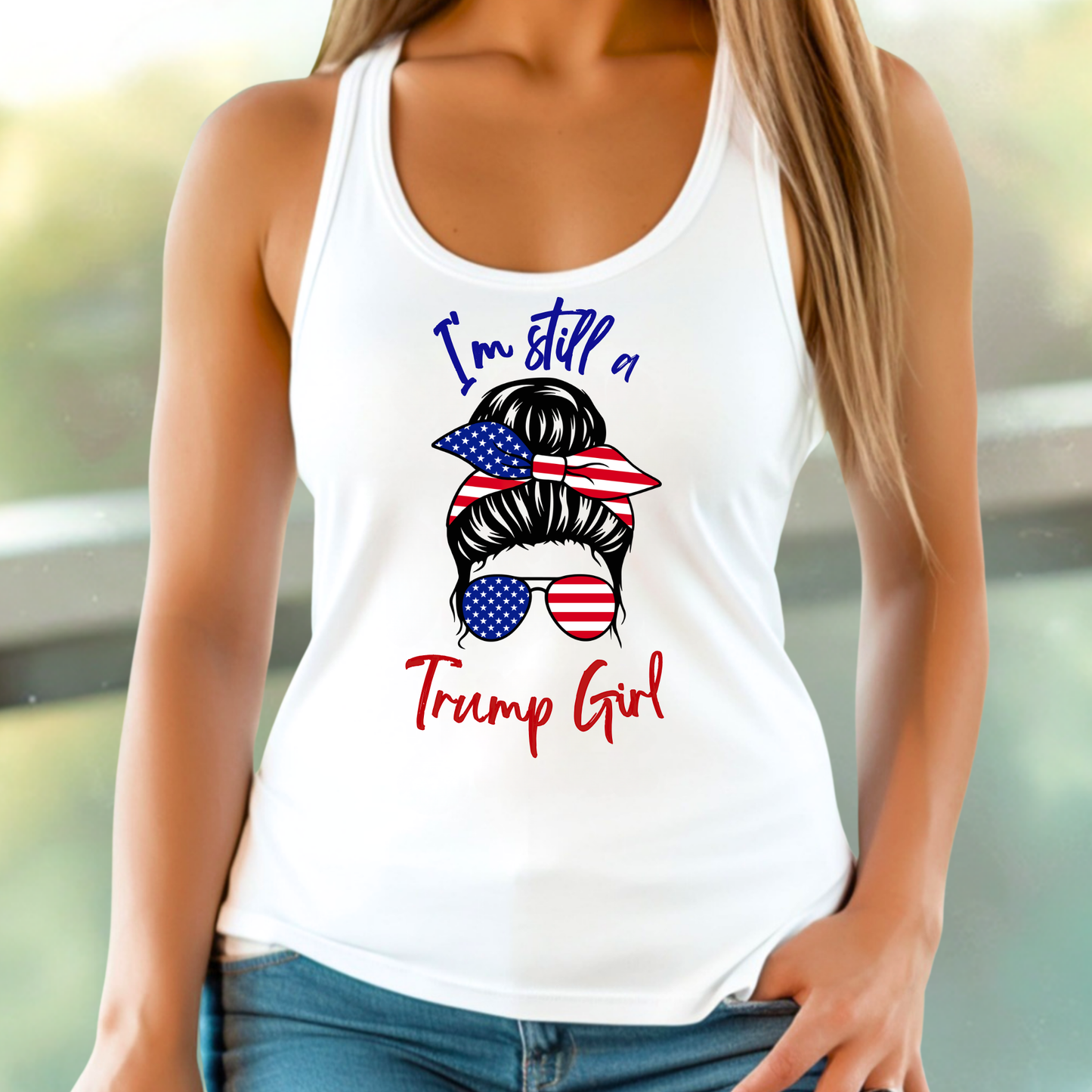 Woman wearing 'I'm Still a Trump Girl' patriotic tank top with American flag bow and sunglasses