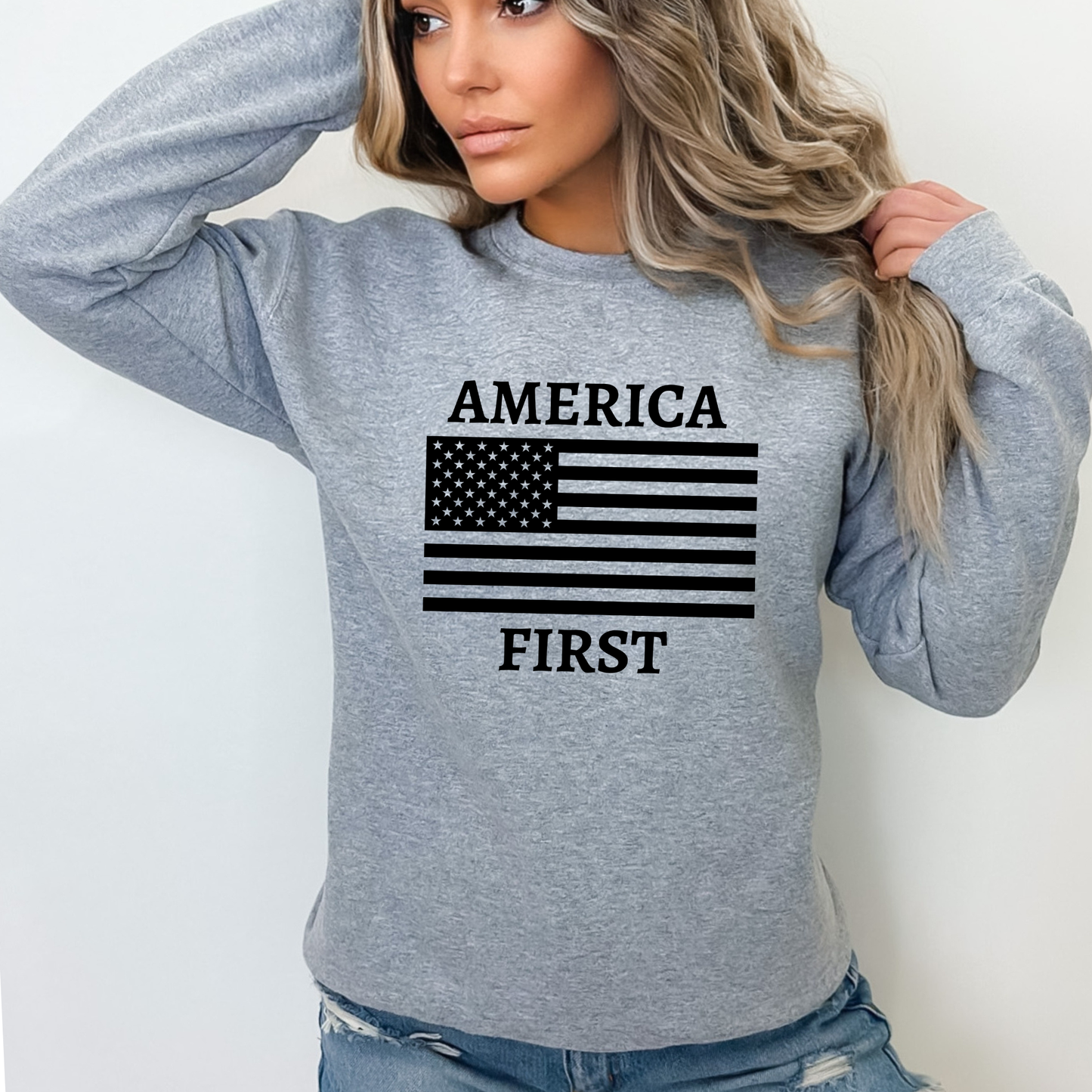 Woman wearing a Sports Gray America First sweatshirt with an American Flag.
