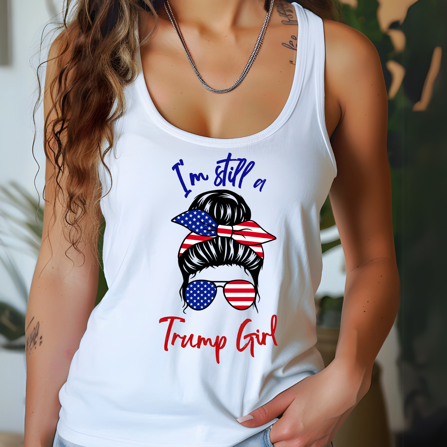Woman wearing 'I'm Still a Trump Girl' patriotic white tank top with American flag bow and sunglasses