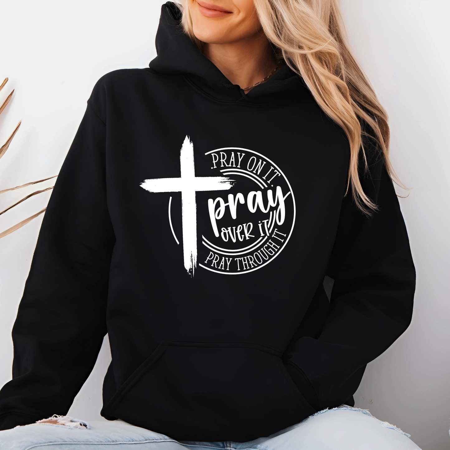 Woman wearing a Black Christian hoodie with a motivational prayer message and cross symbol.