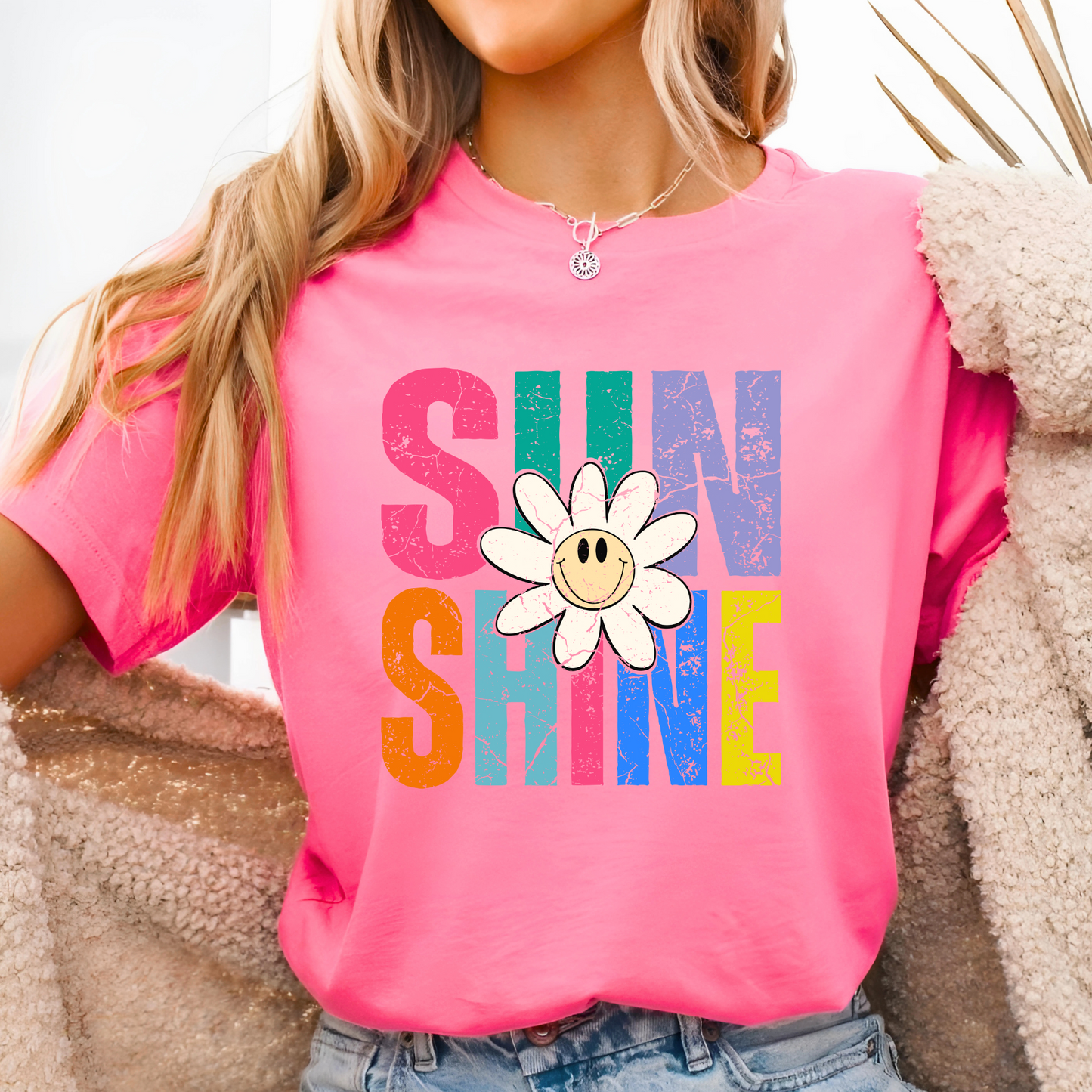 Bright pink tee with bold graphic, styled with fuzzy jacket