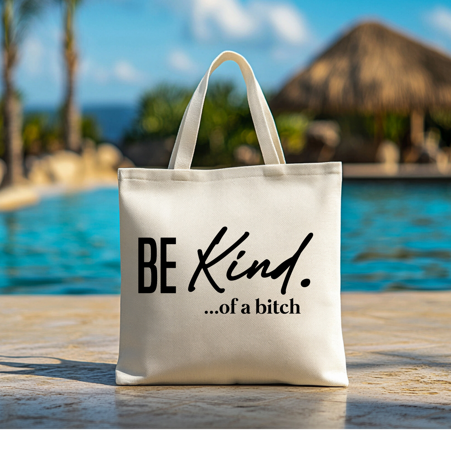 Canvas tote bag near a pool with sassy “Be Kind ...of a Bitch” quote
