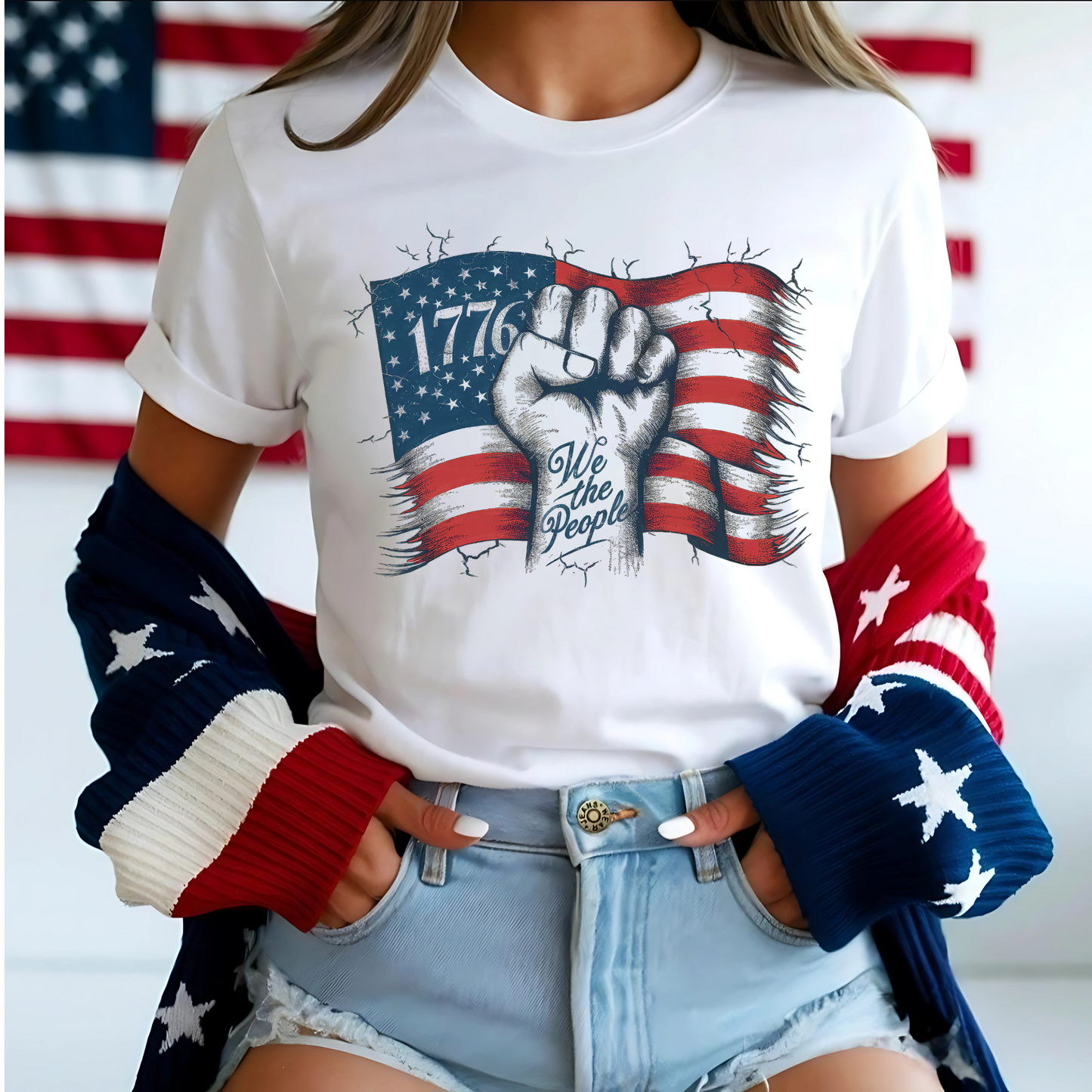 Close-up of patriotic tee with red, white, and blue cardigan, American flag background.