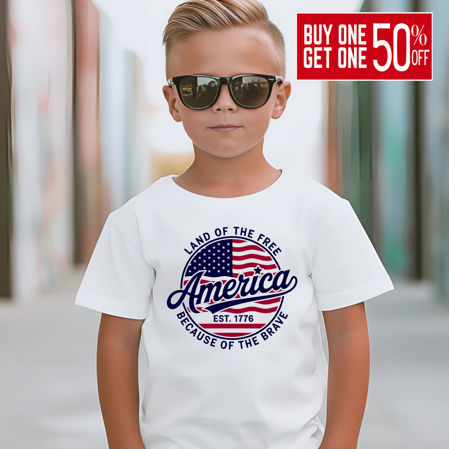 Confident boy in white shirt with sunglasses and patriotic "Land of the Free" graphic