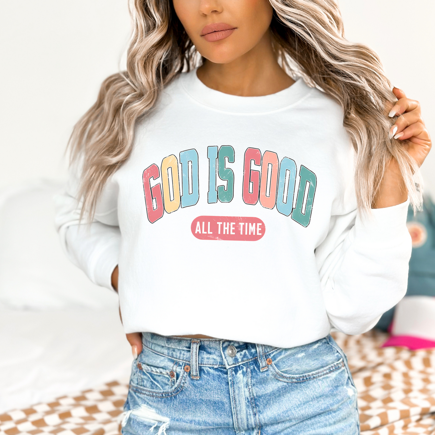 Woman wearing a white 'God Is Good' Christian sweatshirt, faith-based crewneck with inspirational design.