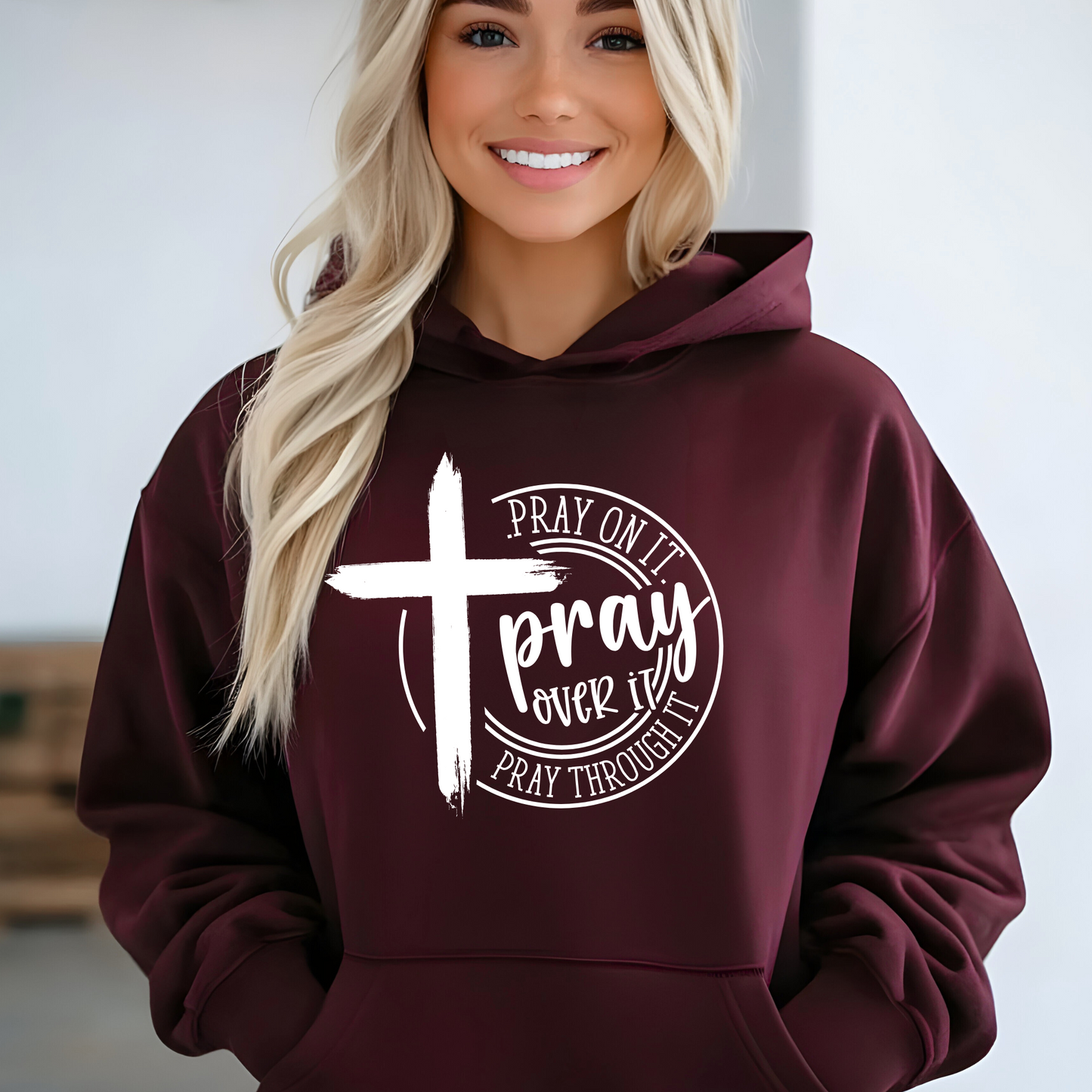 Woman wearing a Maroon Christian hoodie with a motivational prayer message and cross symbol.