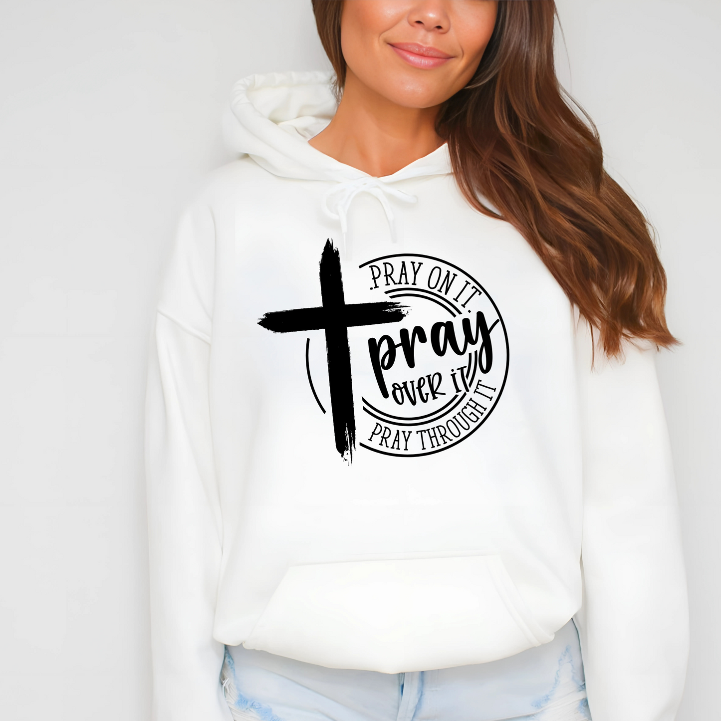 Close-up of a white Christian hoodie with a white cross and ‘Pray Over It’ religious quote.