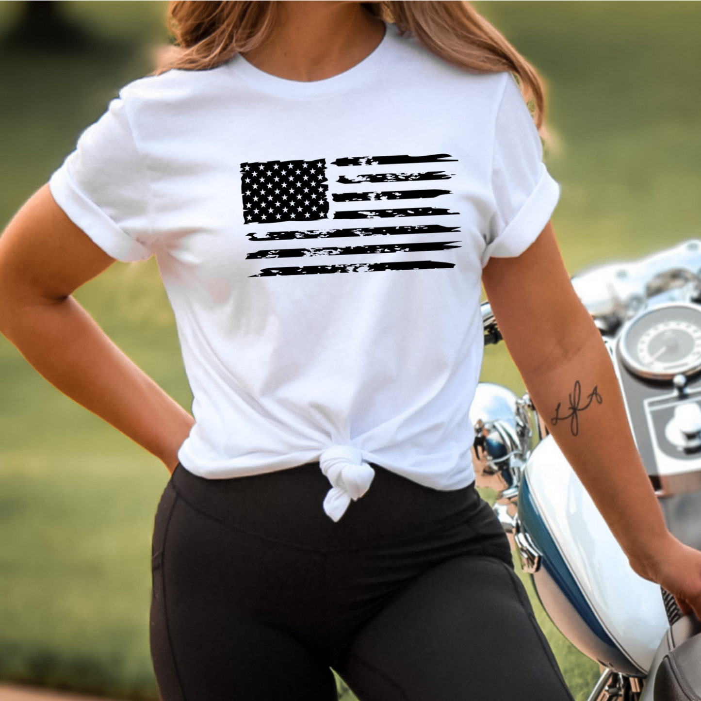 White Trump shirt on woman with rolled sleeves, American flag on chest