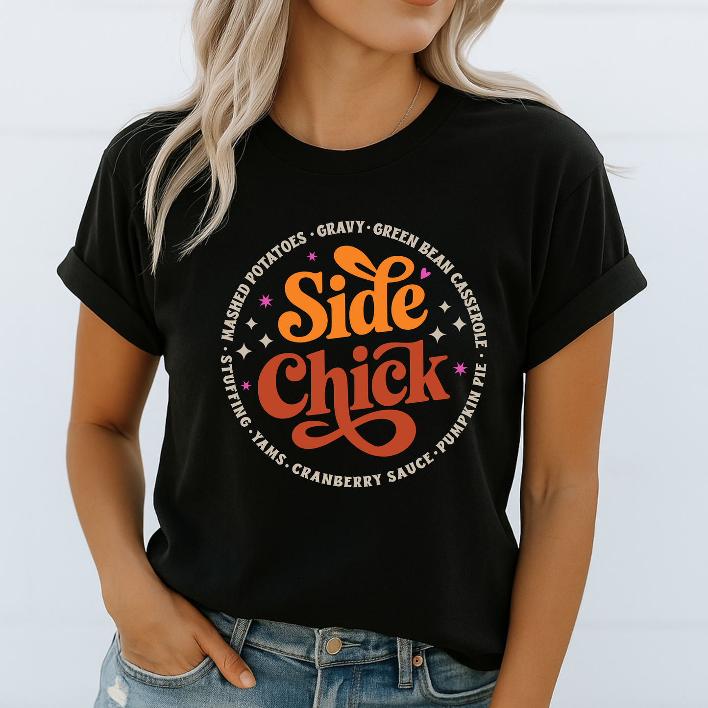 Woman wearing a black “Side Chick” shirt with orange and brown Thanksgiving graphic. Rolled sleeve detail and light-wash jeans create a casual fall look. Bold seasonal design for stuffing and gravy lovers. Ideal for women, teens, and moms who want comfy and funny turkey day fashion.