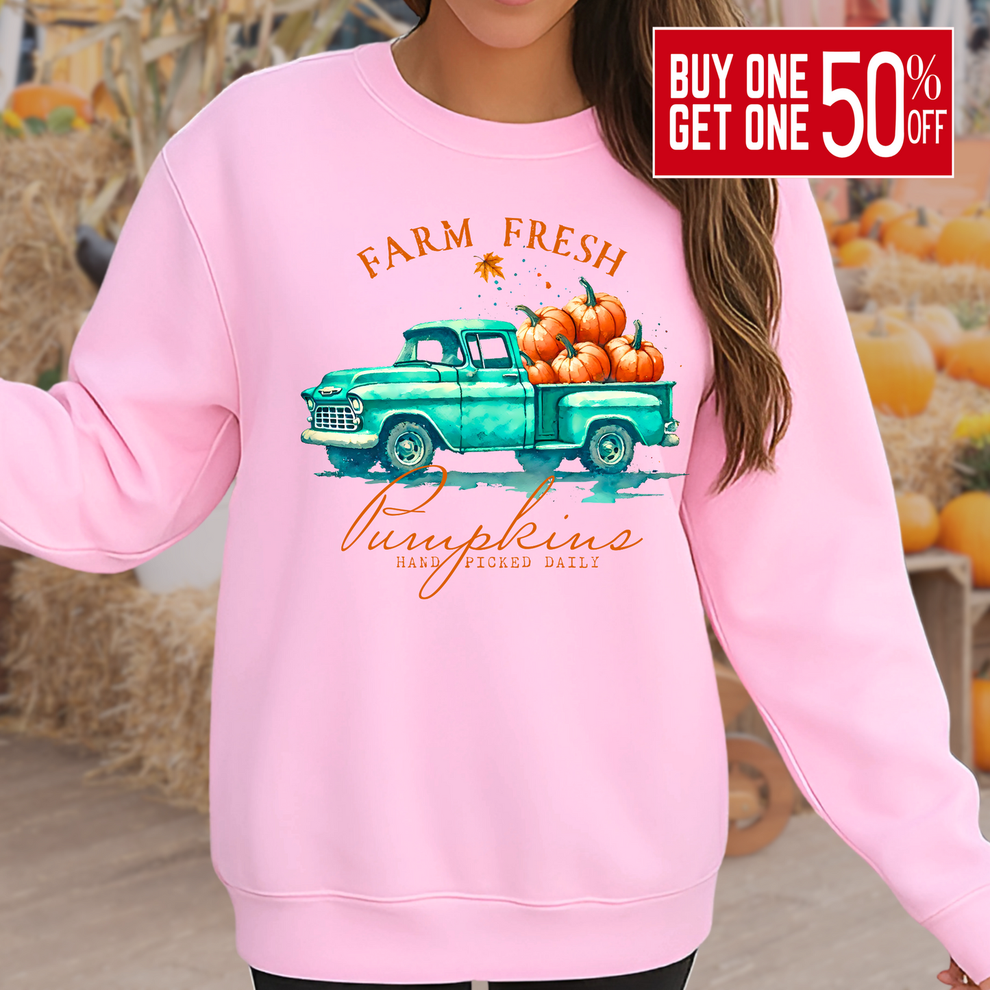 Woman wearing a White sweatshirt with fall truck and pumpkins worn in a pumpkin patch setting