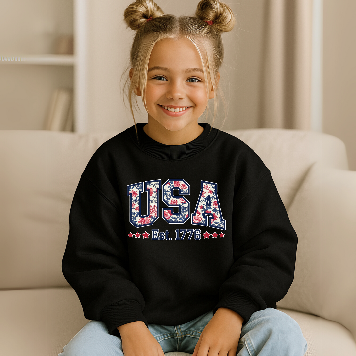 Youth girl wearing black USA Est. 1776 sweatshirt, relaxed pose at home.