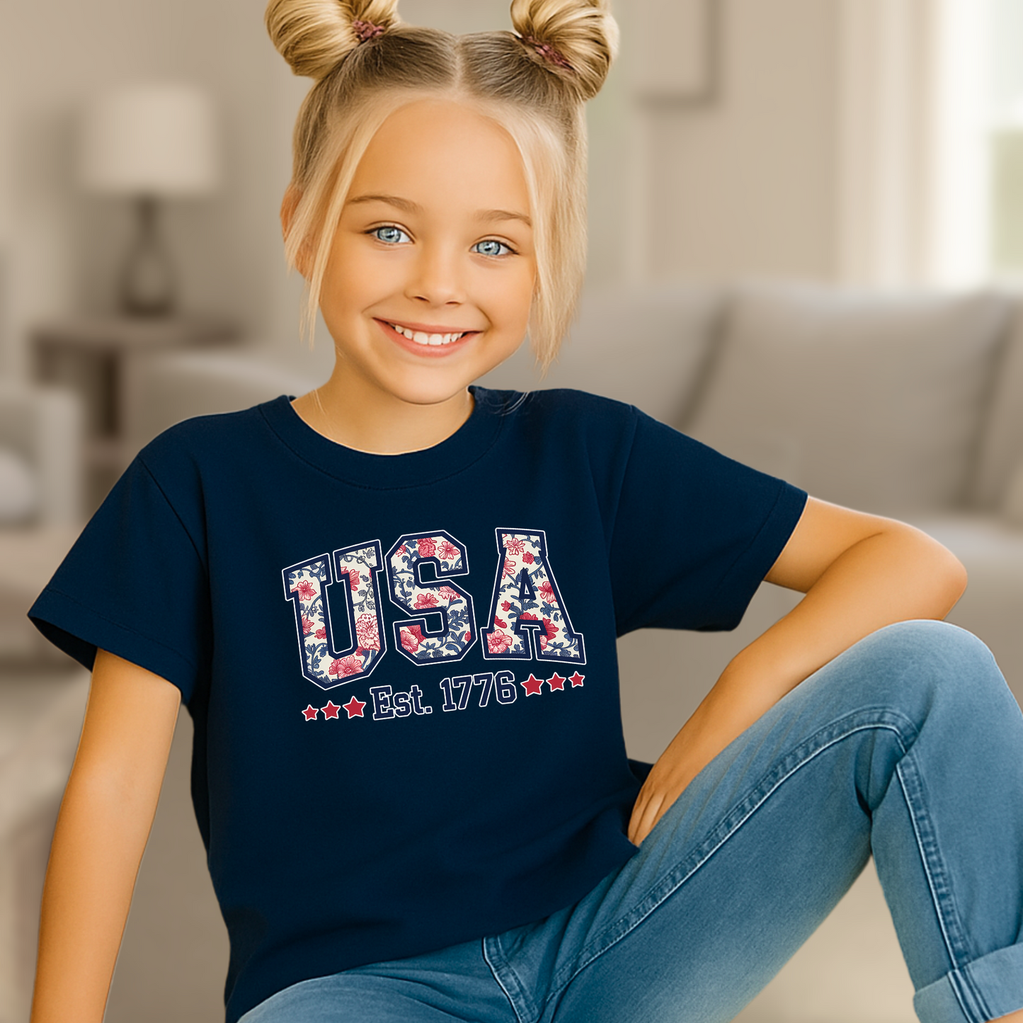Youth model in navy blue USA Est. 1776 shirt, cozy home setting.