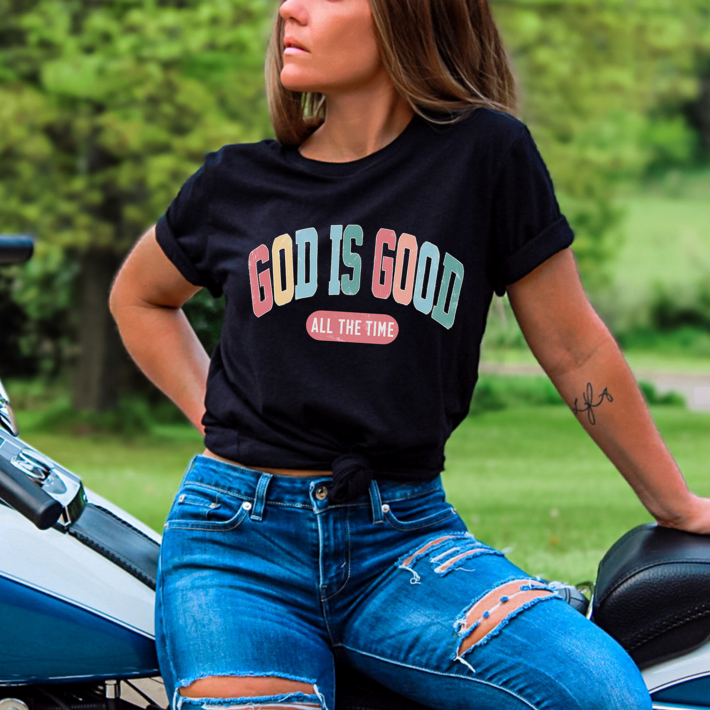 Woman wearing a black ‘God Is Good All The Time’ Christian t-shirt, faith-based graphic tee.