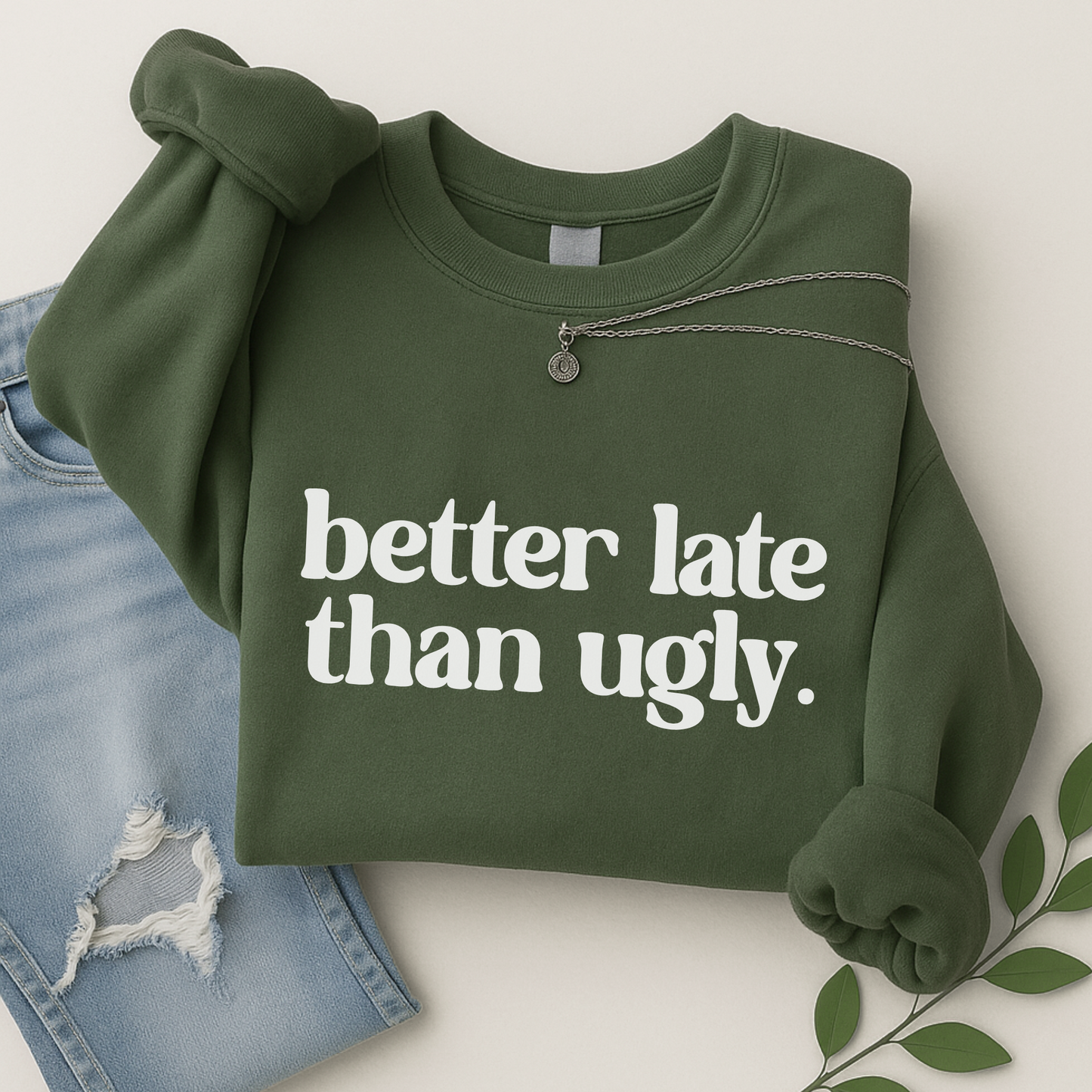 green crewneck sweatshirt with “Better Late Than Ugly” in bold white font. Folded flat with jeans and layered necklace. Perfect for fall fashion, this unisex pullover offers warmth and sass for teen girls and women.