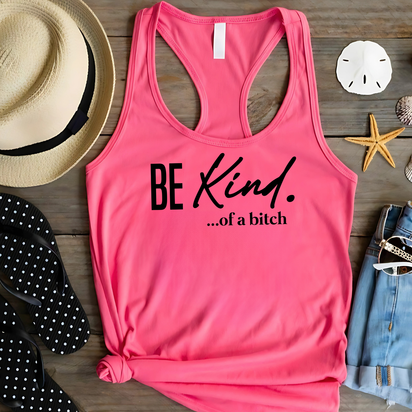 pink racerback tank top with “Be Kind…of a bitch” text worn by woman with blonde hair