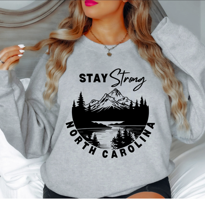 Show your support for those affected by Hurricane Helene in Western North Carolina with this custom "North Carolina Stay Strong" design. The majority of proceeds from these sales will be donated directly to families affected. GRAY SWEATSHIRT 