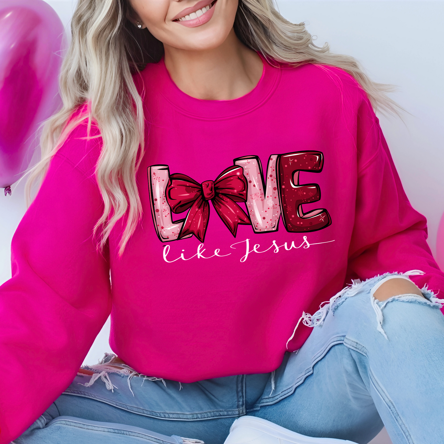 A woman wearing a pink sweatshirt with the text 'LOVE  printed on the front.