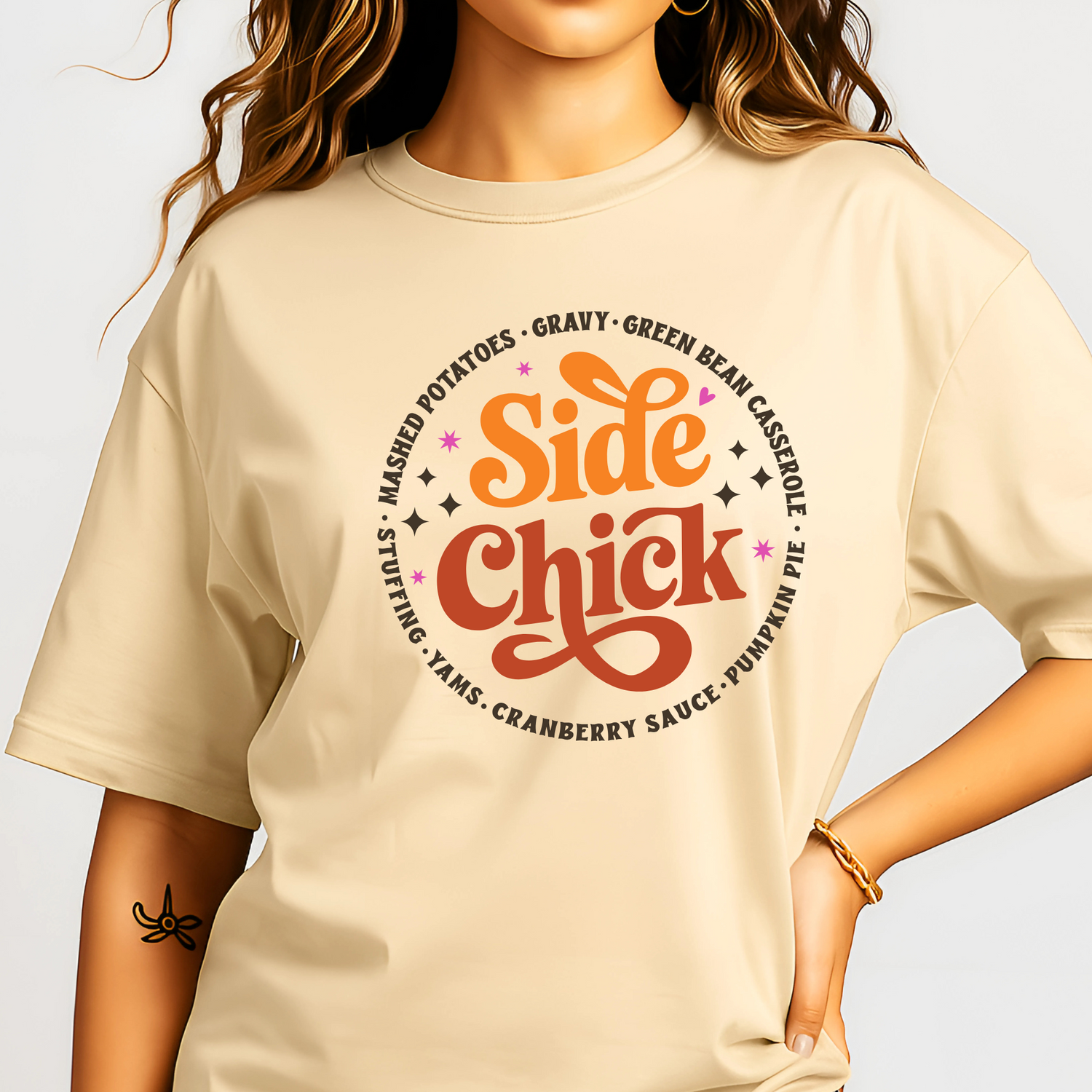 Adult woman modeling a sand-colored “Side Chick” t-shirt featuring festive side dish design in warm fall tones. The perfect neutral tee for Thanksgiving or Friendsgiving gatherings. Soft cotton blend with a relaxed unisex fit for comfort and style all season long.