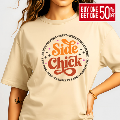 Adult woman modeling a sand-colored “Side Chick” t-shirt featuring festive side dish design in warm fall tones. The perfect neutral tee for Thanksgiving or Friendsgiving gatherings. Soft cotton blend with a relaxed unisex fit for comfort and style all season long.