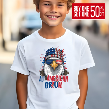 Child wearing a white t-shirt with an eagle graphic and text, standing outdoors.