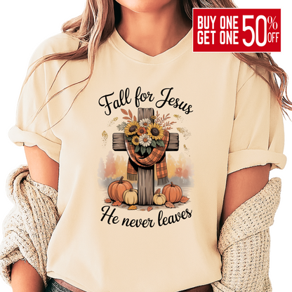 Person wearing a beige t-shirt with 'Fall for Jesus He never leaves' design featuring pumpkins and a cross.