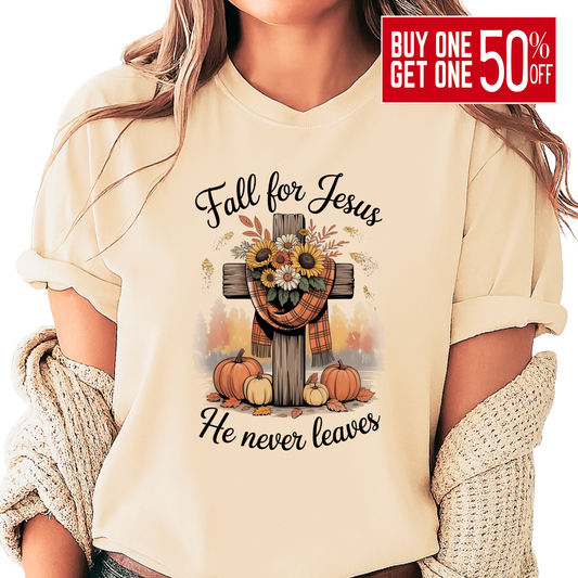 Person wearing a beige t-shirt with 'Fall for Jesus He never leaves' design featuring pumpkins and a cross.
