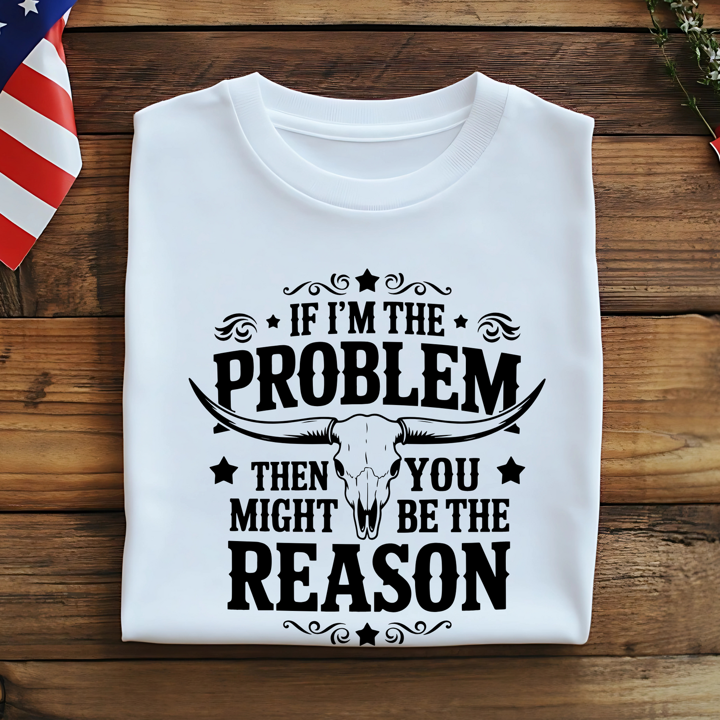 Folded white tee with black graphic and American flag accent – flat lay on wooden table

