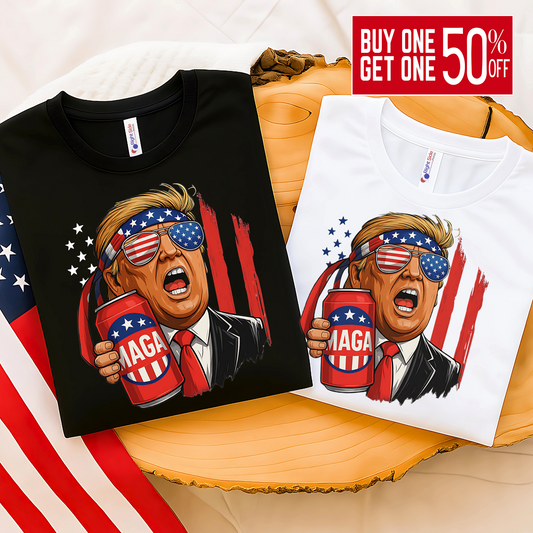 Folded black and white tees with Trump MAGA beer print, USA flag in background, perfect for patriotic gift ideas.