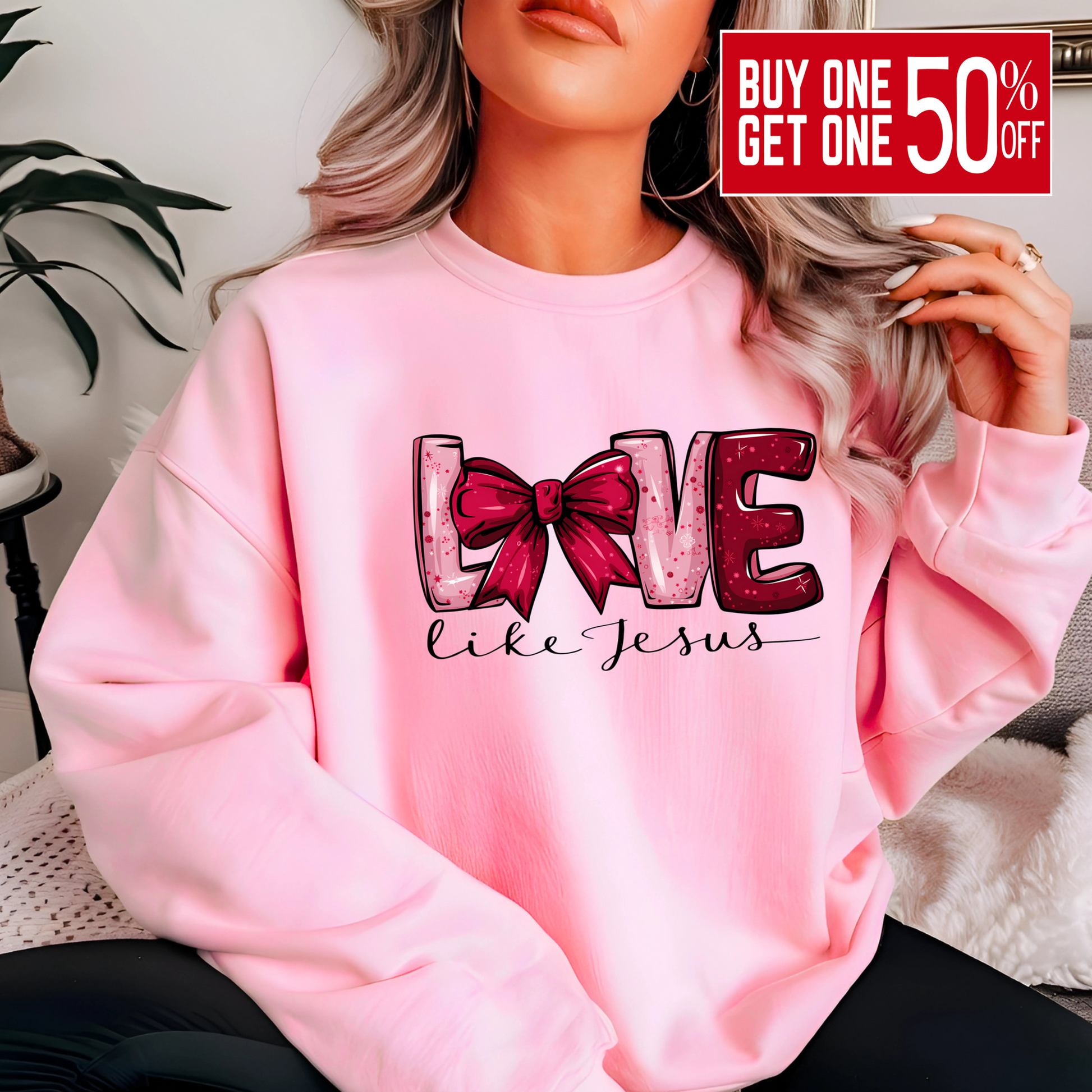 Person wearing a pink sweatshirt with 'LOVE' text and bow design.