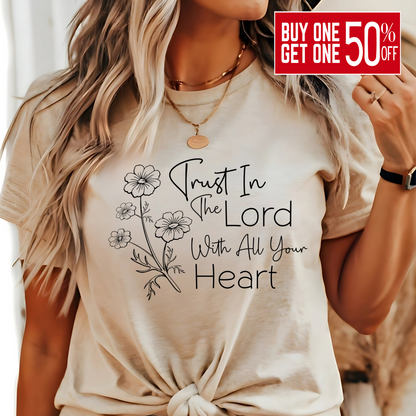 Woman wearing tan T-shirt with floral graphic and “Trust in the Lord With All Your Heart” text.