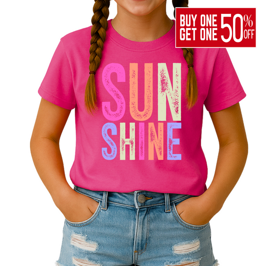 Girl in hot pink “Sunshine” tee and denim shorts, smiling
