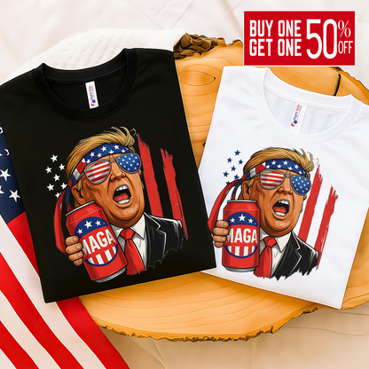 Folded black and white tees with Trump MAGA beer print, USA flag in background, perfect for patriotic gift ideas.