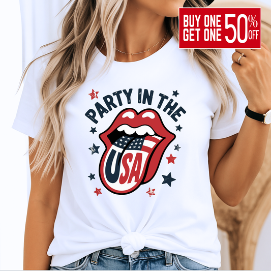 Woman wearing a white “Party in the USA” T-shirt with bold patriotic lips and flag tongue design, styled with a front knot. Perfect for 4th of July BBQs, Memorial Day events, and summer USA pride outfits.

