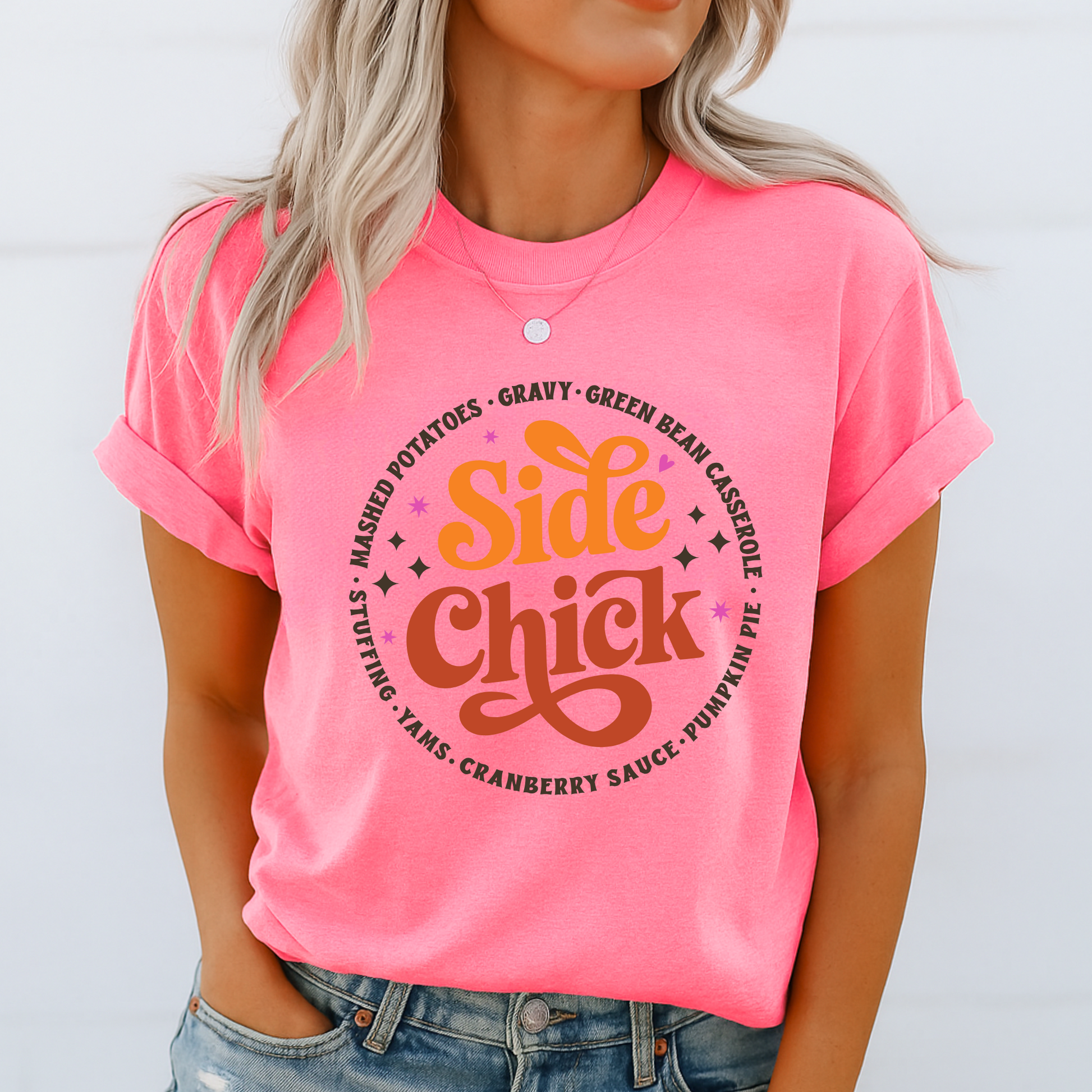 Woman in a bright pink “Side Chick” unisex tee styled with rolled sleeves and jeans. Eye-catching holiday design highlights favorite Thanksgiving sides in retro fonts. Great statement shirt for women and teens celebrating Turkey Day in bold, playful style.