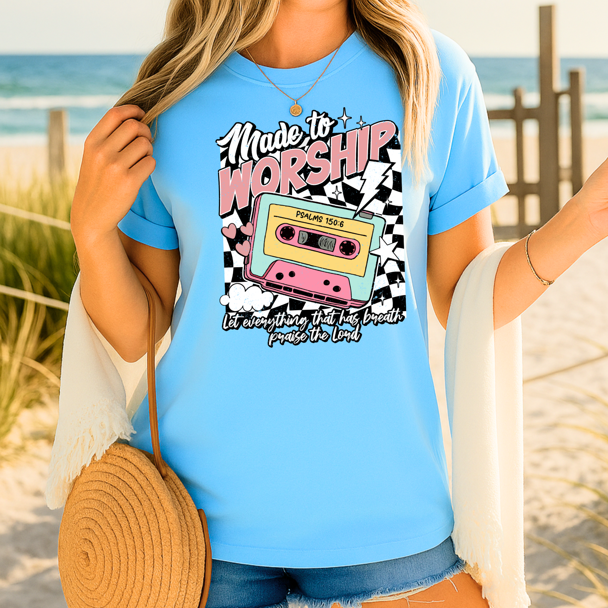 Woman in beach setting wearing pastel worship cassette tee
