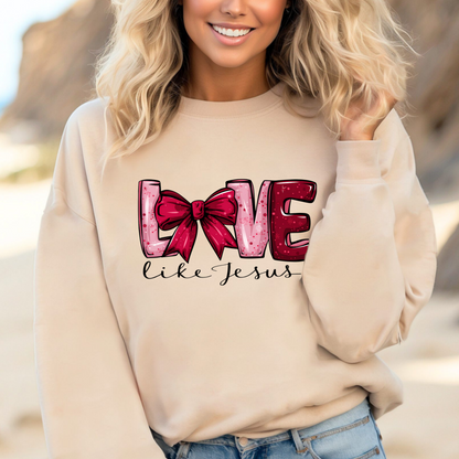 Woman wearing a beige sweatshirt with 'Love' text and red bow graphic on a beach.