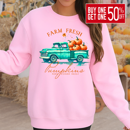 Woman wearing a White sweatshirt with fall truck and pumpkins worn in a pumpkin patch setting