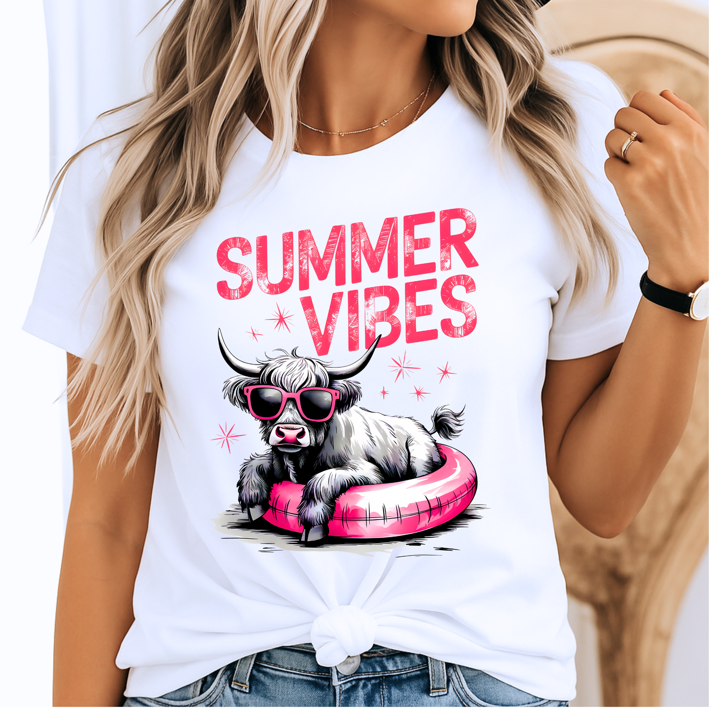 Woman wearing white t-shirt with “Summer Vibes” and cow in pink float graphic