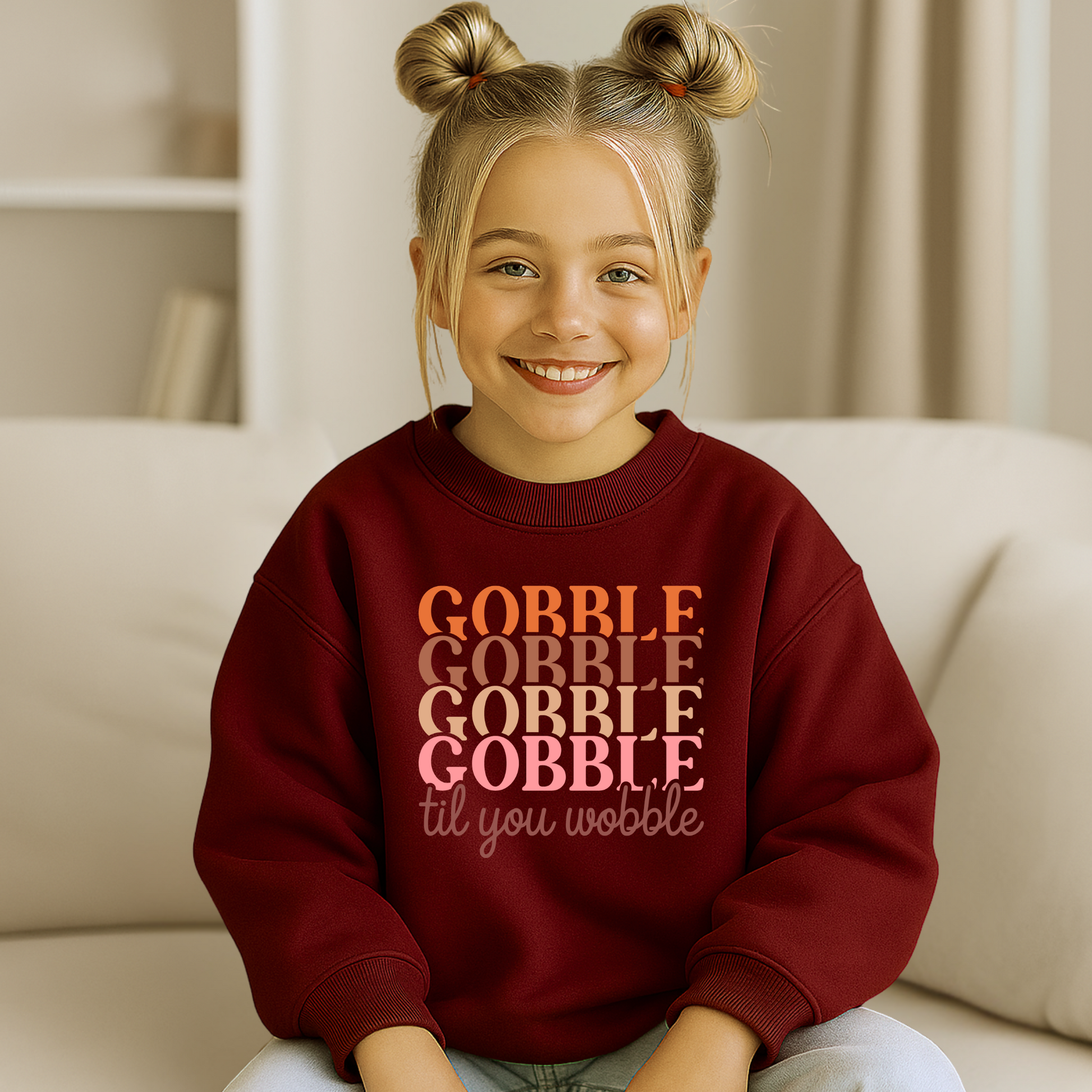 Youth girl modeling a maroon fall sweatshirt with “Gobble Til You Wobble” in multicolored print. Cozy Thanksgiving pullover for kids, great for girls’ turkey day outfits and seasonal photos.