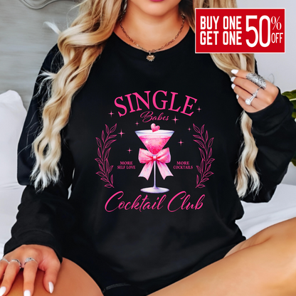 Person wearing a black sweatshirt with pink 'Single Babes Cocktail Club' design.