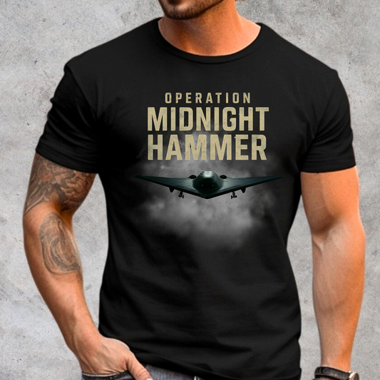 Operation Midnight Hammer shirt featuring B-2 Spirit stealth bomber in flight through stormy clouds, symbolizing elite stealth airpower and patriotic military strength. Black unisex graphic tee perfect for veterans, air force supporters, and patriotic Americans.