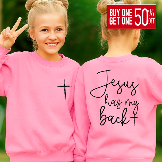 Two pink sweatshirts with a cross and 'Jesus has my back' text, worn by a girl outdoors.