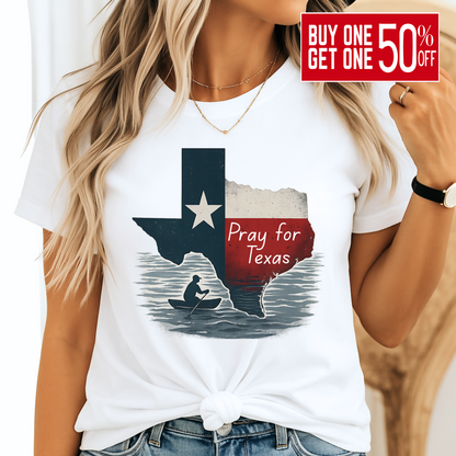 White unisex Pray for Texas T-shirt featuring a distressed Texas flag graphic with "Pray for Texas" text and a silhouette of a person in a canoe. Casual women's outfit paired with denim, perfect for Texas pride and support.